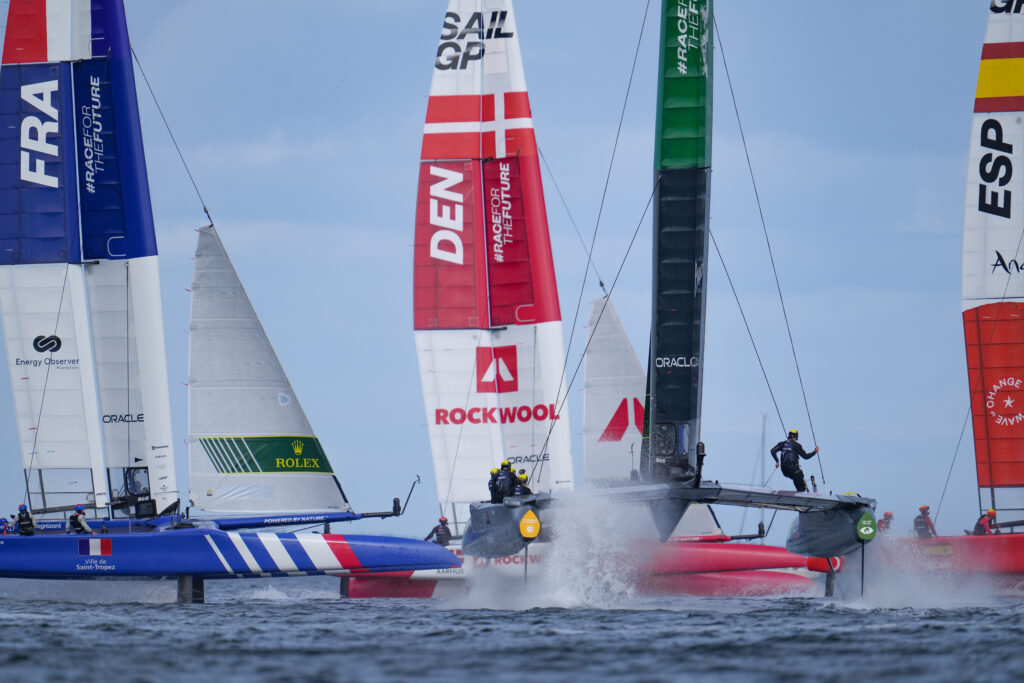 Several sail GP boats next to each other on different tacks.