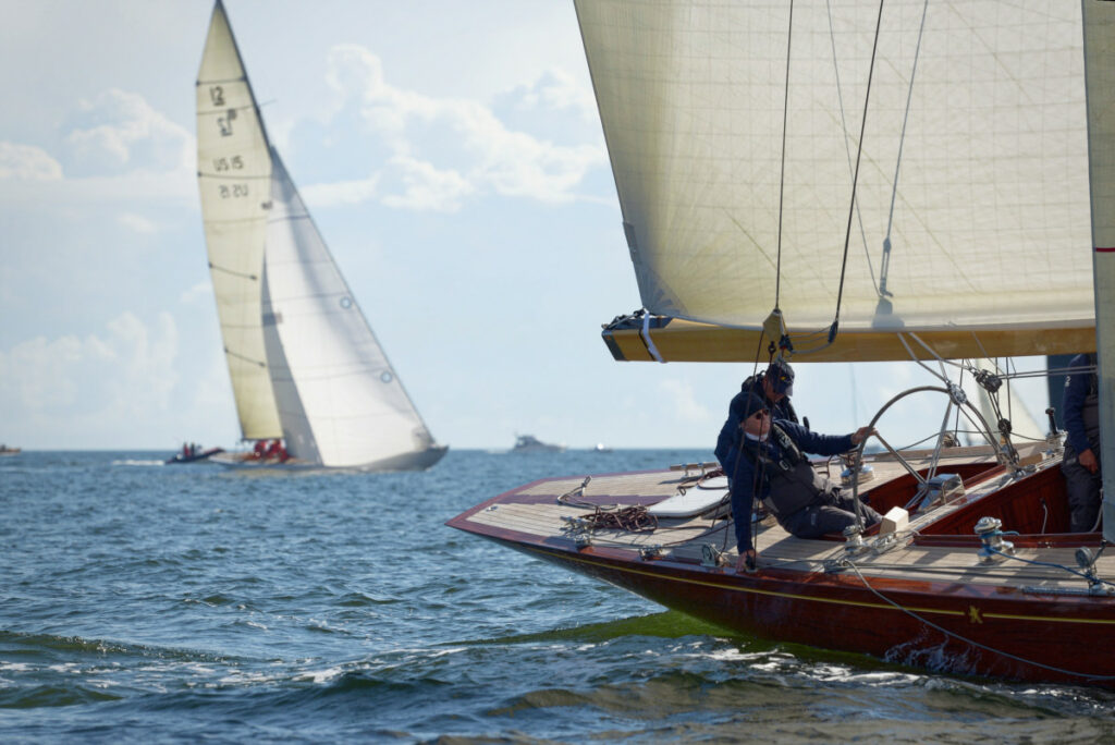 A wooden boats healing from crew weight in light winds.