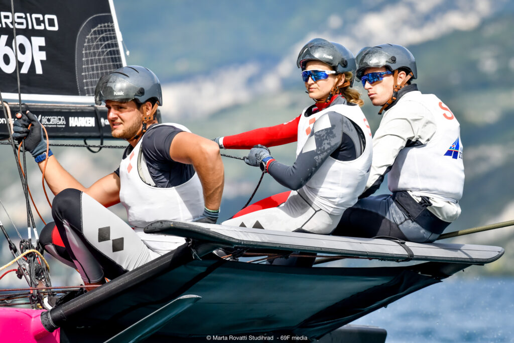 Close-up of three crew members racing.