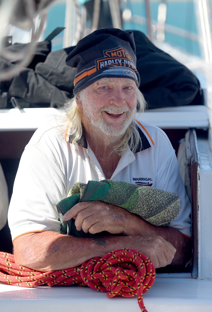 Jimmy Finch stadning on the stairs of his boat, smiling. 