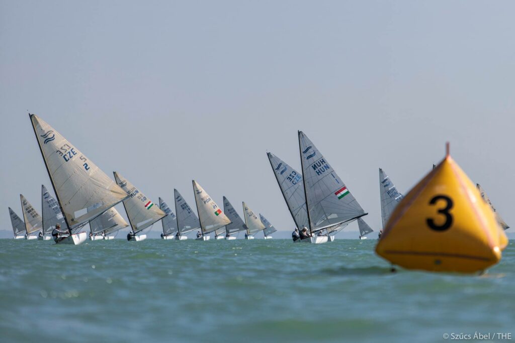 The fleet sailing downwind, towards a yellow mark. 