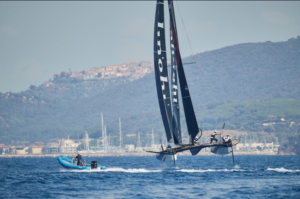 Alinghi on a reach, next to a powerboat.