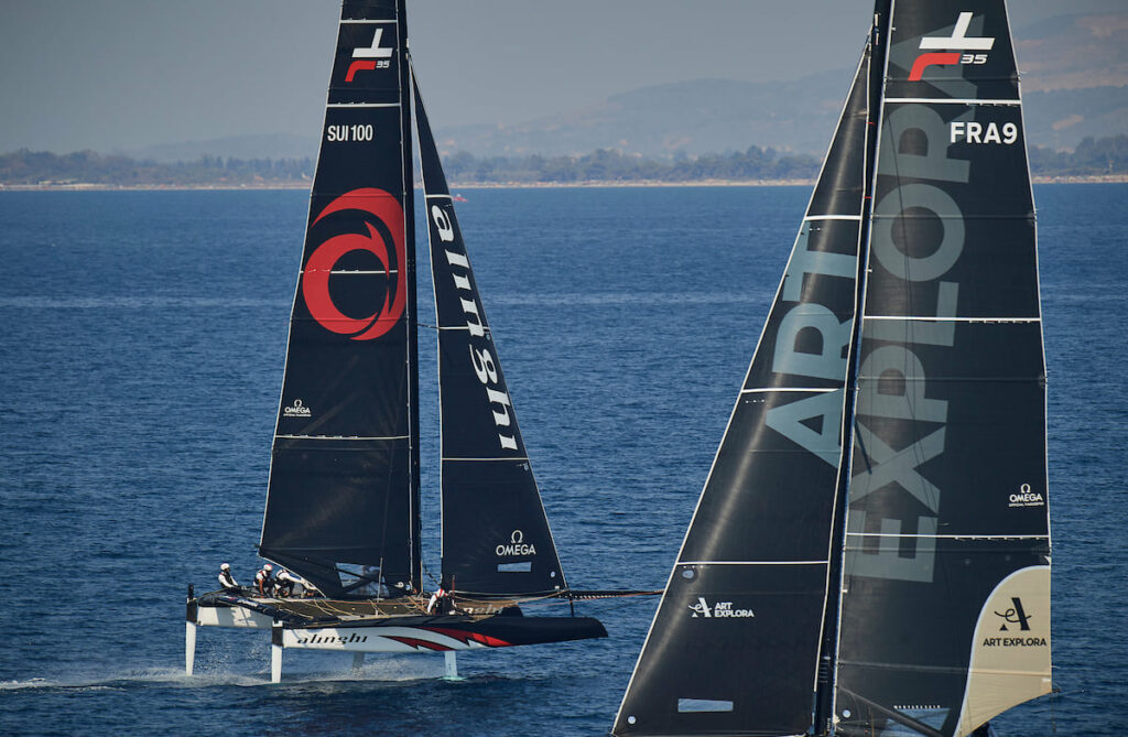 Alinghi sailing downwind, while a competitor sails upwind.