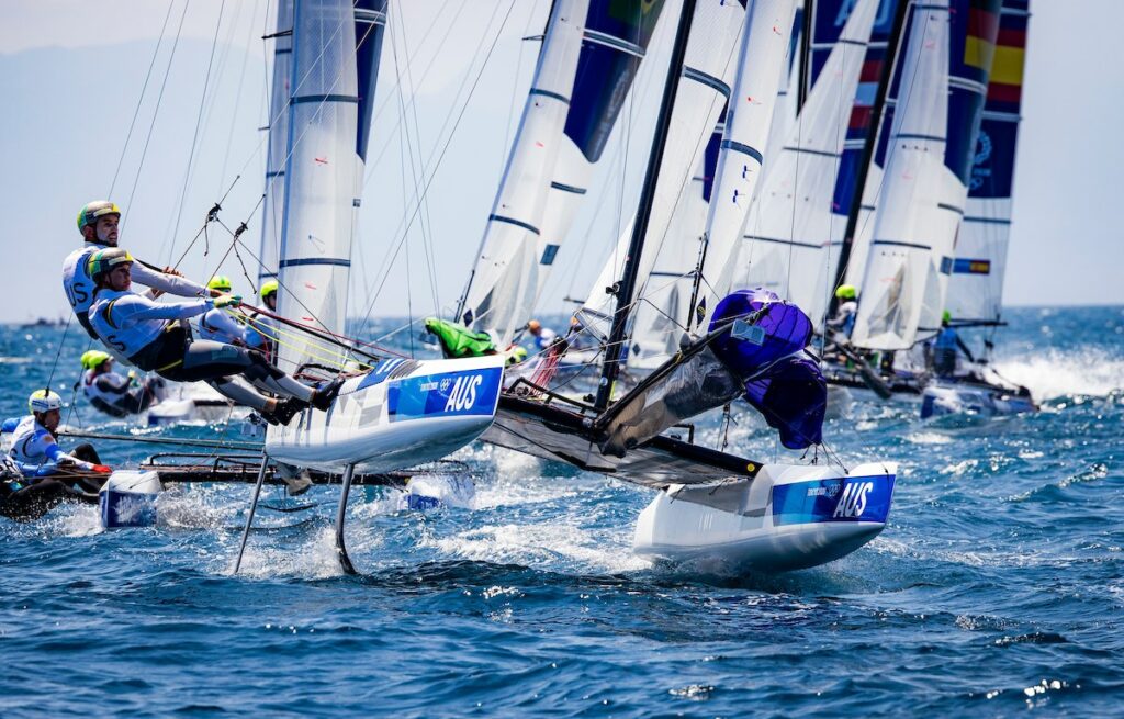 Jason Waterhouse and Lisa Darmanin sailing the nacra 17 on foils, followed by a bunch of boats.