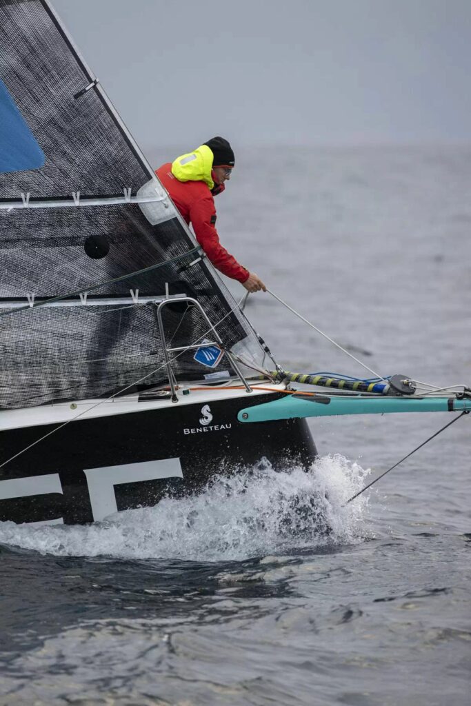 Xavier Macaire leaning over the bow sprit, where the foiling kite sits.