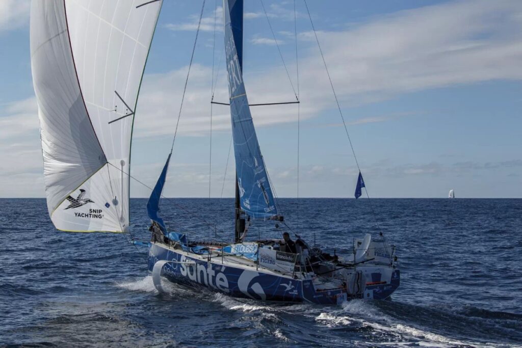 Fabien Delahaye sailing downwind with a white kite.