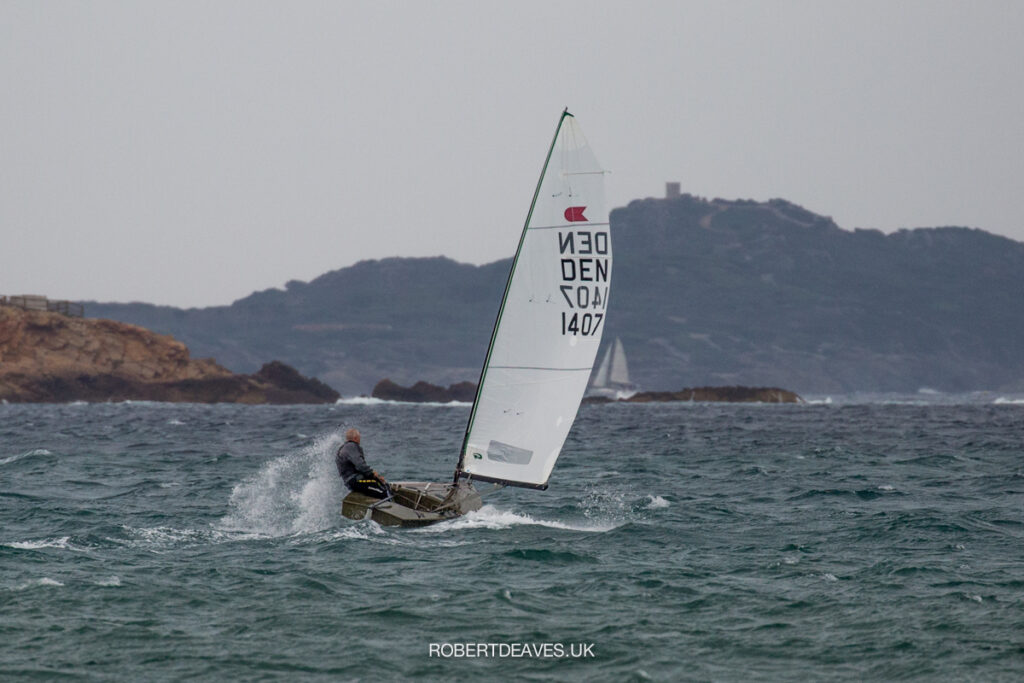 An OK Dinghy sailing off the beach, on a run.