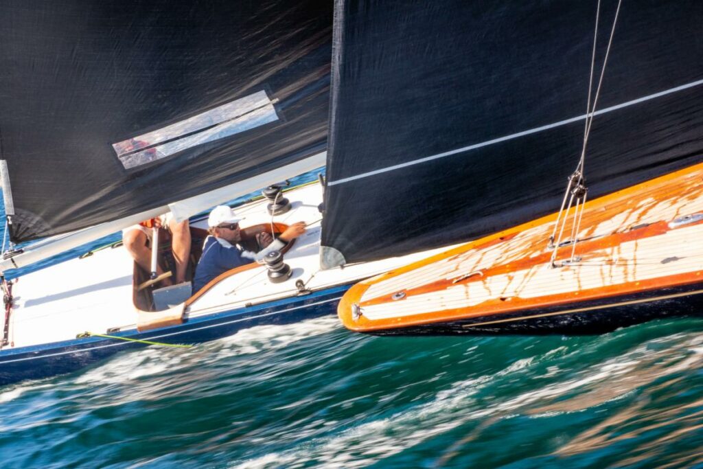 Two Six Metre yachts sailing next to each other upwind.