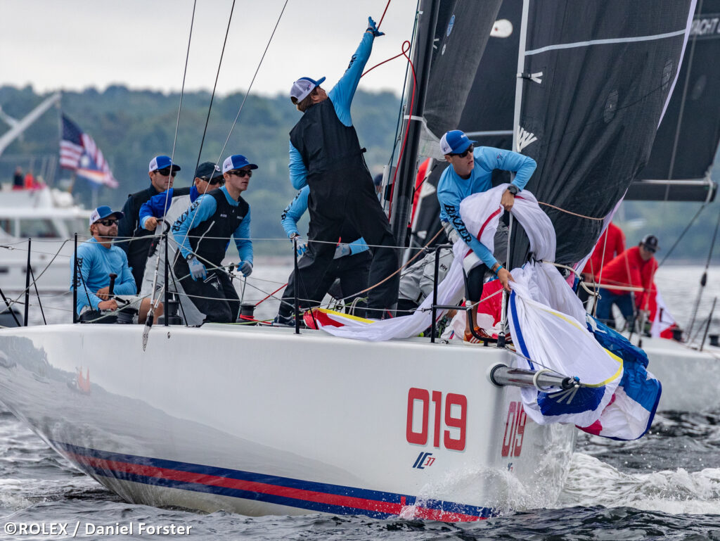 New York Yacht Club sailing downwind. Bow team are hoisting the spinnaker.