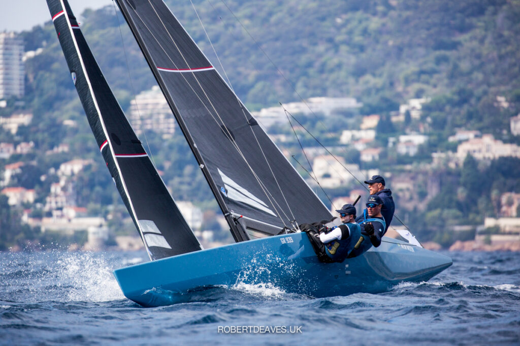 New Moon, blue hull, sailing upwind, crew hiking.