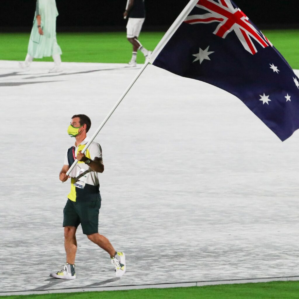 Mat Belcher holding the Australian flag at the Closing Ceremony.