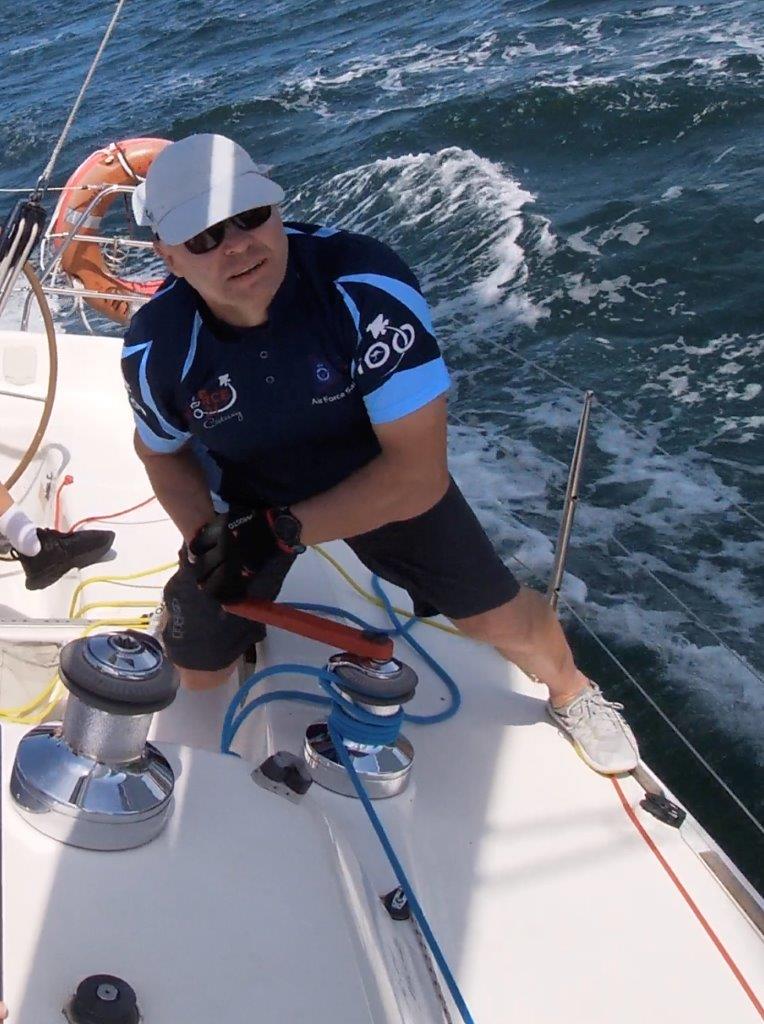 Darrell Greig winding a winch while sailing.