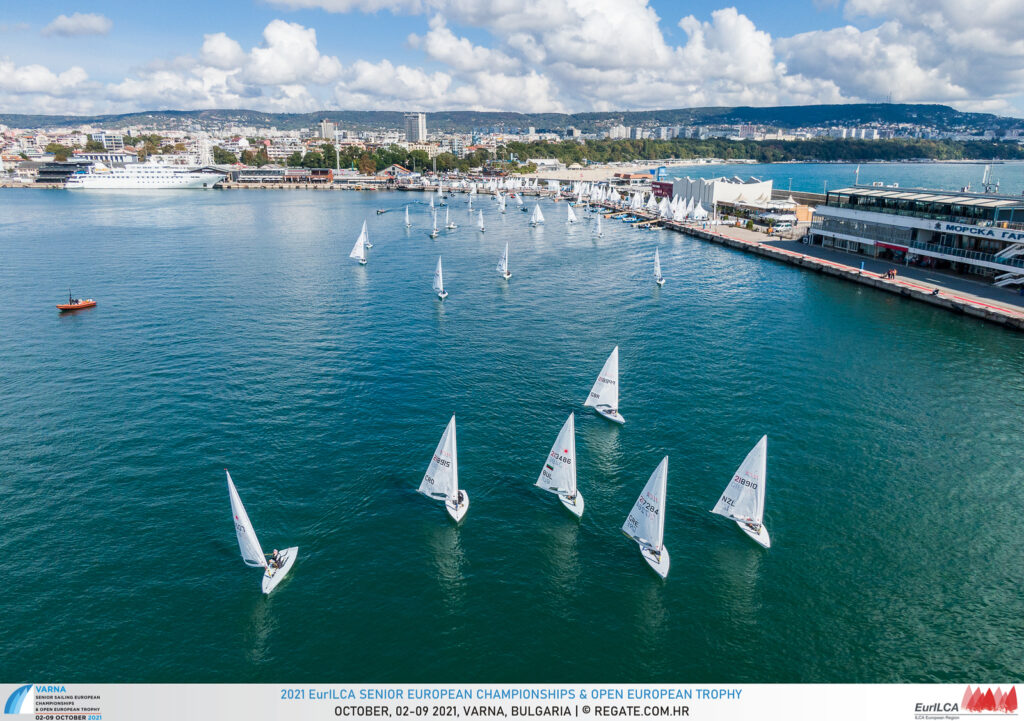 Aerial shot of Lasers sailing out from land on a run.