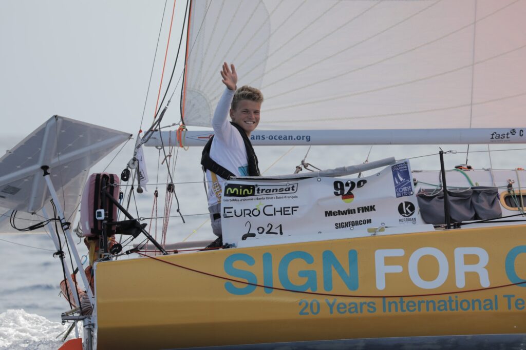 Melwink Fink on his boat smiling and waving