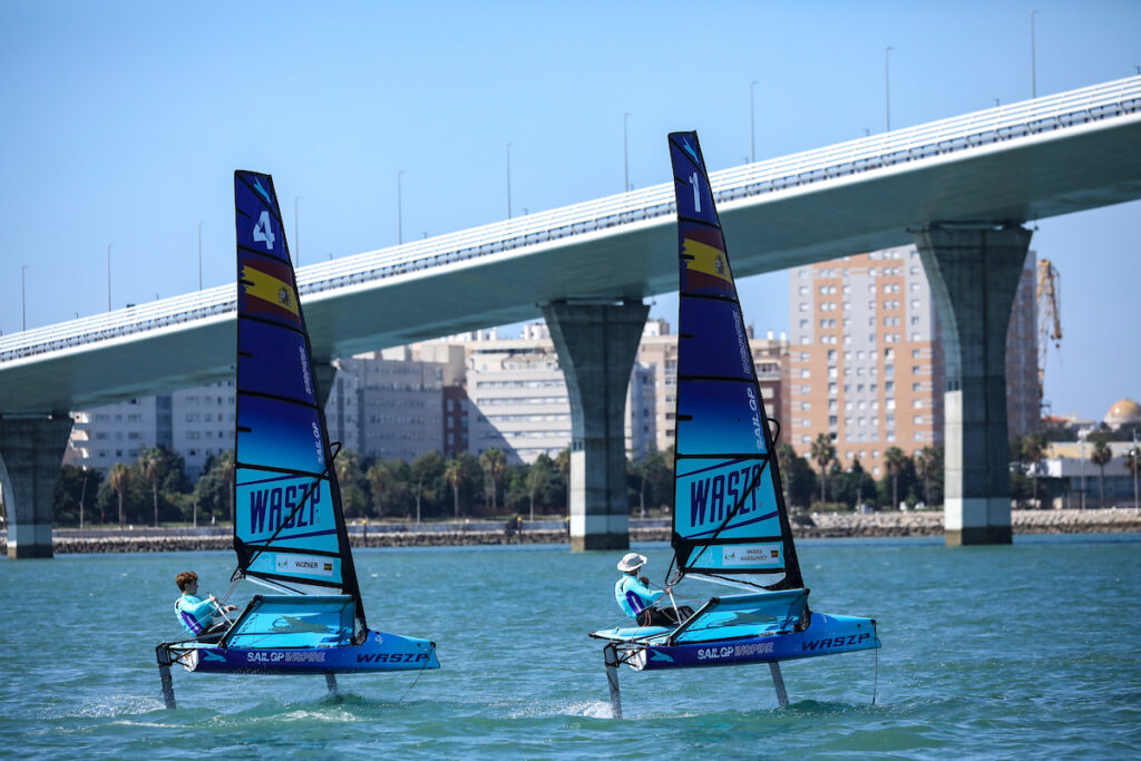 Two waszps sailing upwind, heading towards a bridge.