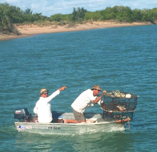 Two people on a tinny with crab pots