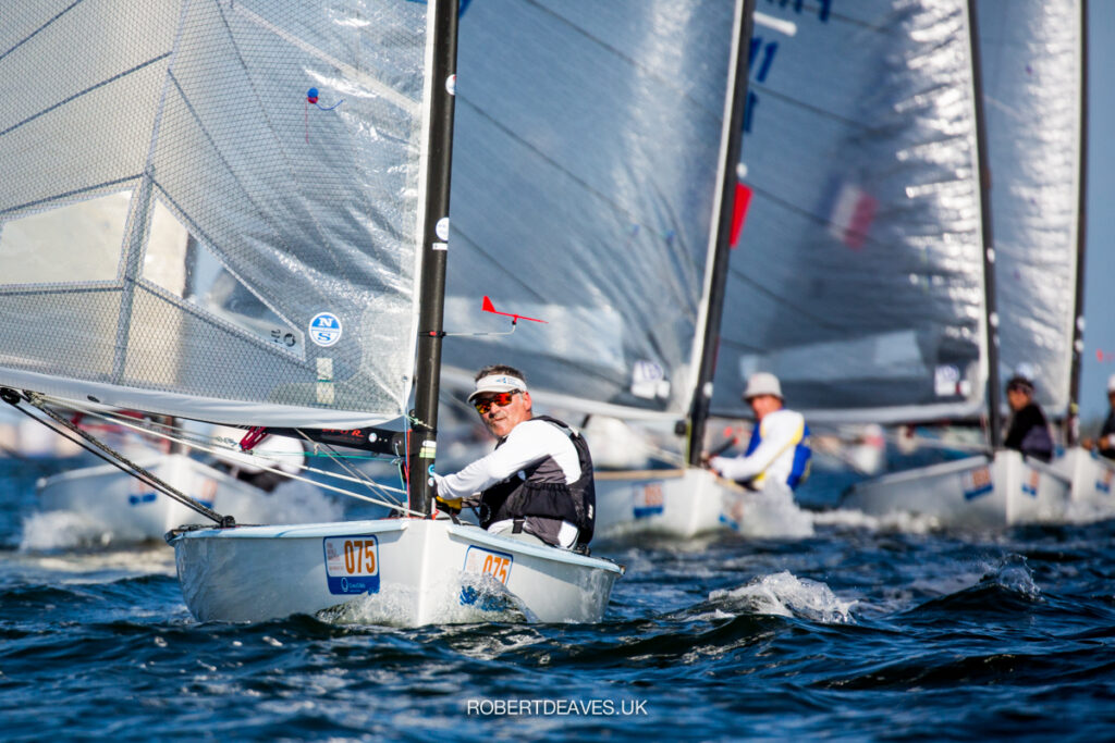 Laurent Ray sailing downwind with the fleet behind him.