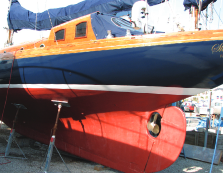 Yacht with large red keel on hard stand.