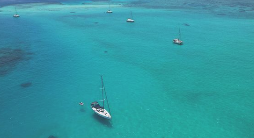 An aerial shot of yachts in crystal clear Queensland waters.