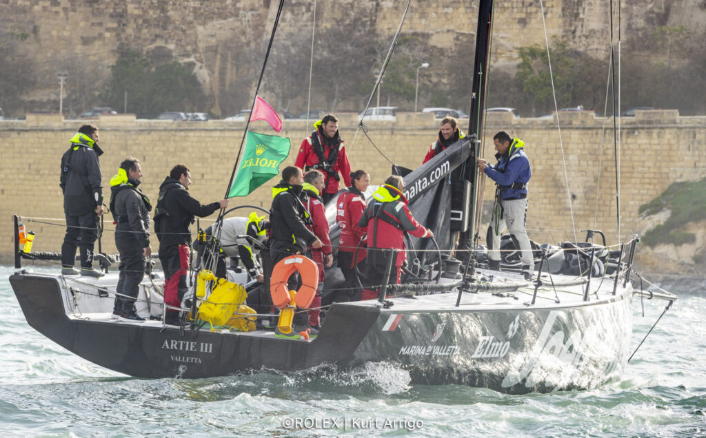 Artie III team taking the main sail down as the motor into the dock.