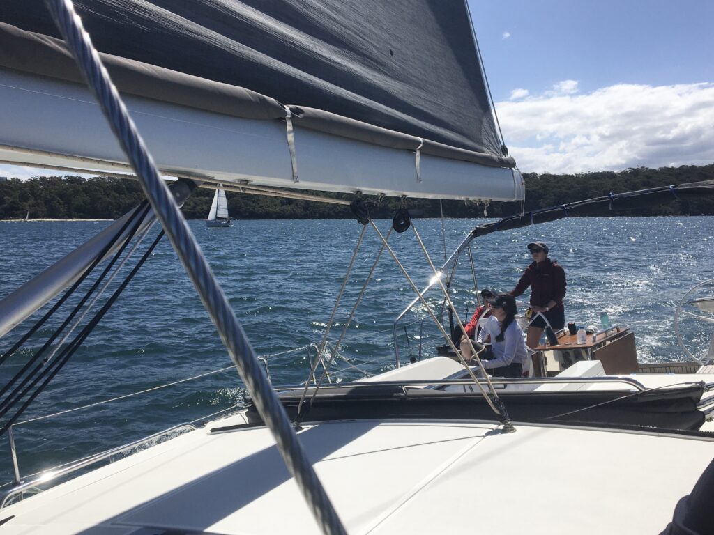 From the middle of the boat, looking back to the cockpit where the skipper is at the wheel.