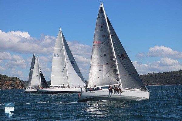 Four boats side by side, sailing upwind.