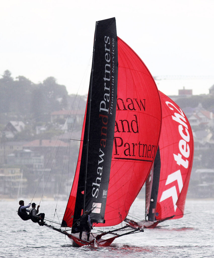 Two skiffs in a line on a spinnaker reach.