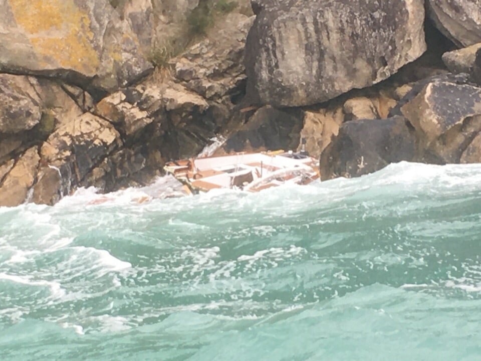 Boat falling to pieces on rocks.