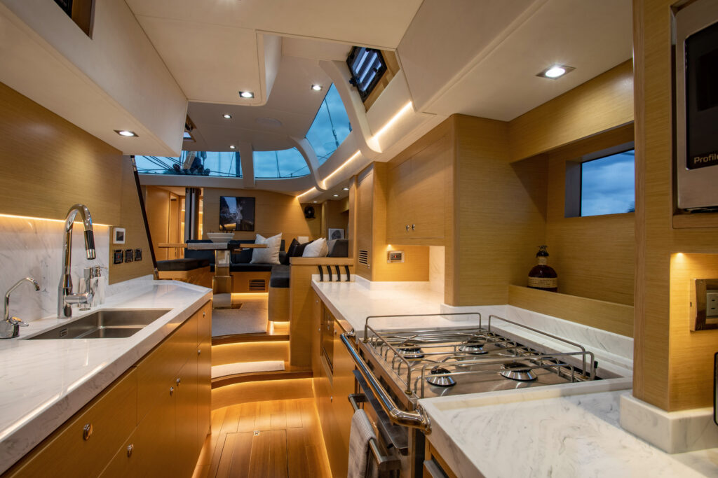 Interior: galley, looking onto living room table. Windows above, curving with the room.