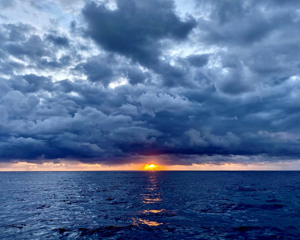 Sunset underneath heavy cloud cover.