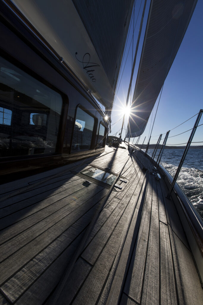 Deck shot of Atao, sun shining between the headsail and forestay.