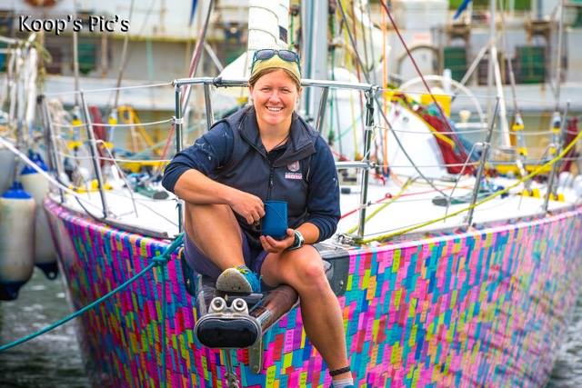 Lisa Blair on the bow of her boat on the dock.