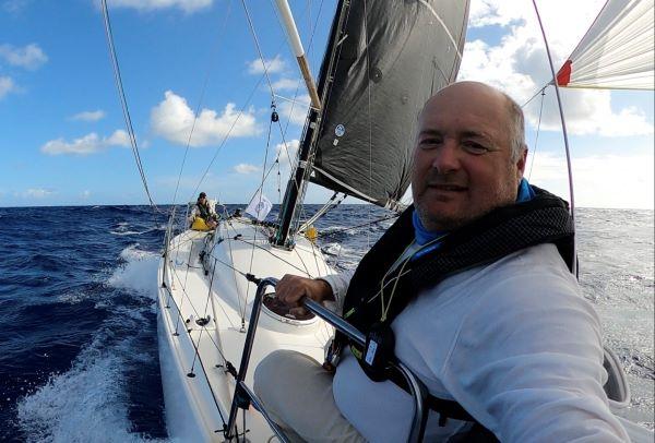 Selfie of crew members from bow, other crew member towards the stern. On a kite run.