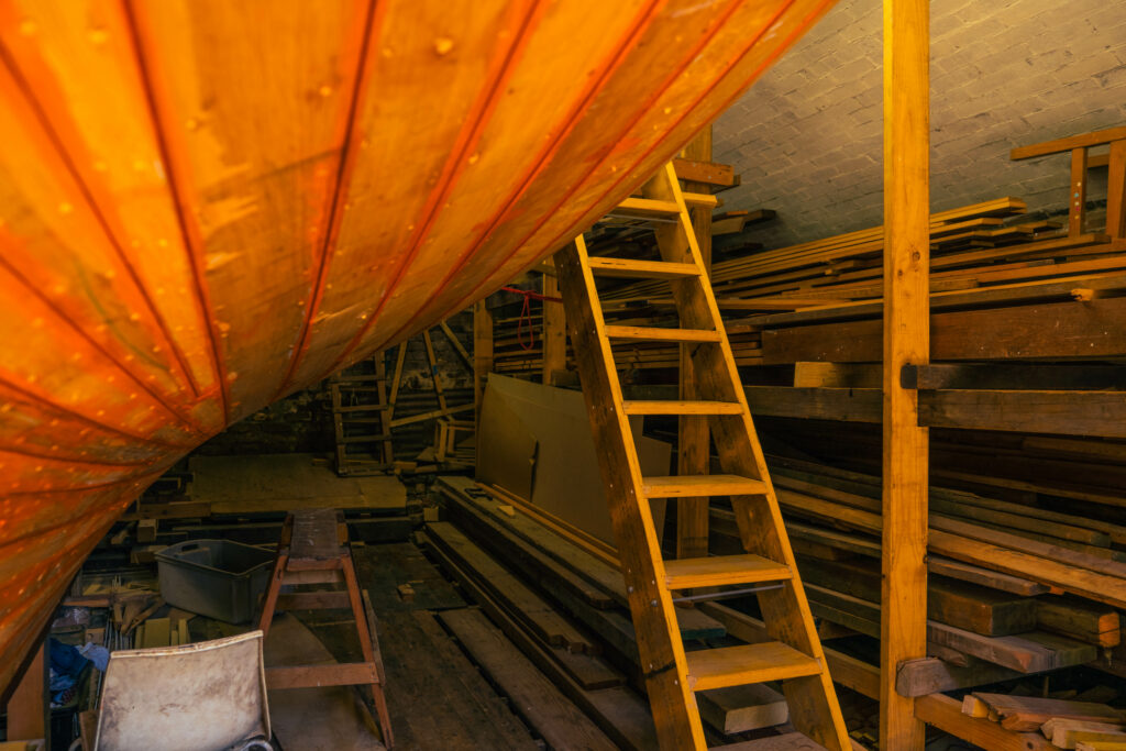 Wooden hull inside a shed.