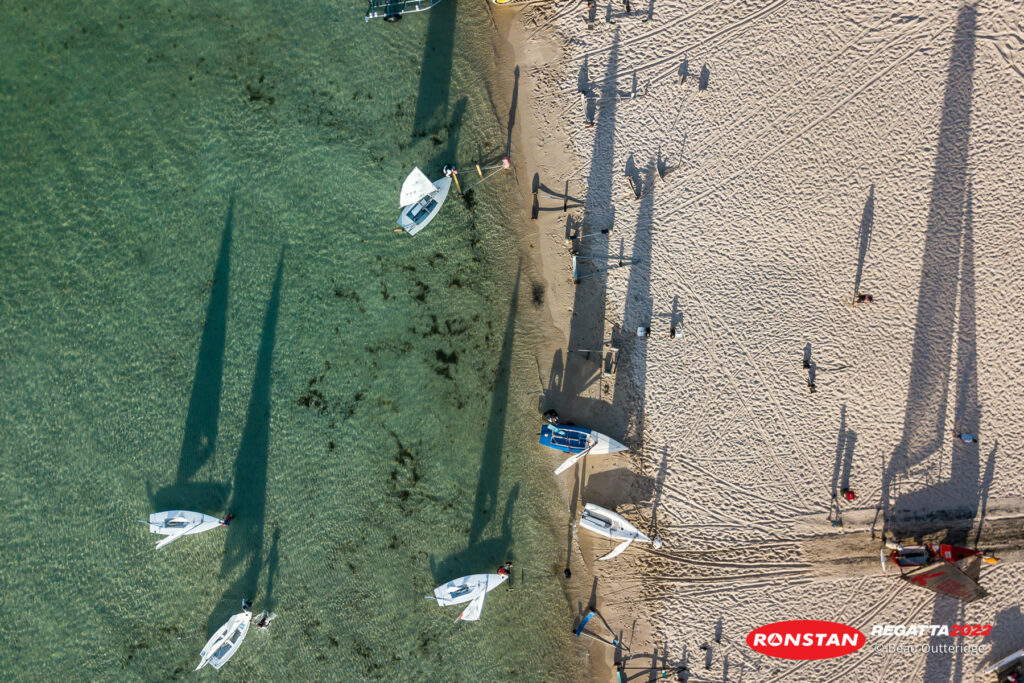 Aerial shot of people launching their boats from the beach.