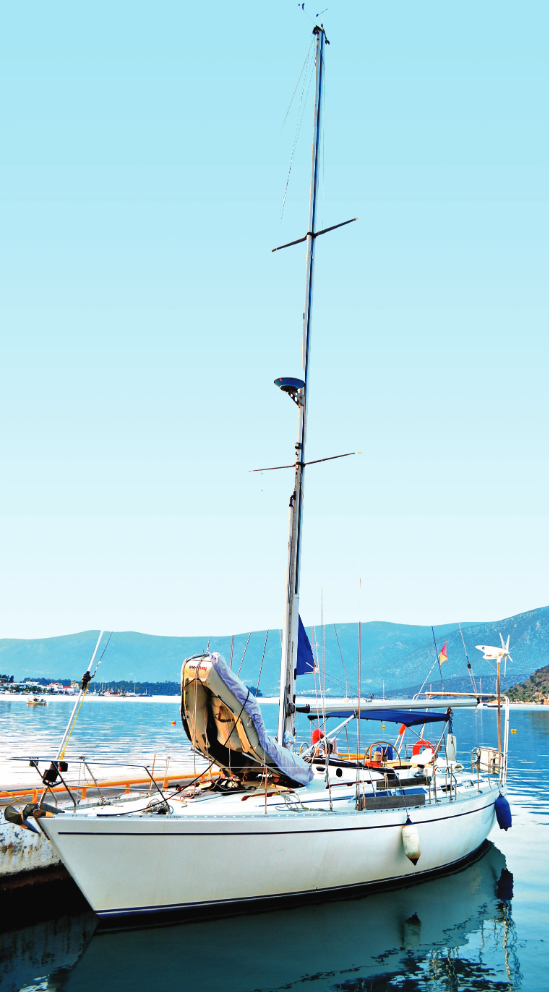 Yacht along side dock, mountains in the background.