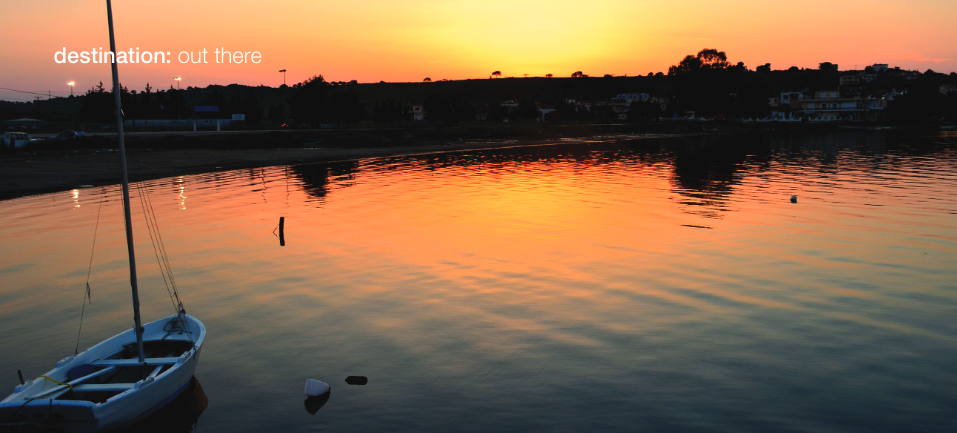 Sunset over the water. Dinghy sitting by its mooring.