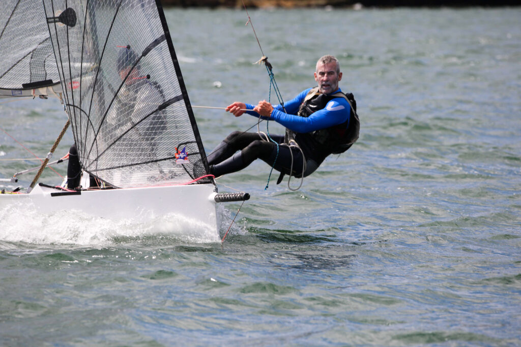 Crew on trap harness to windward.