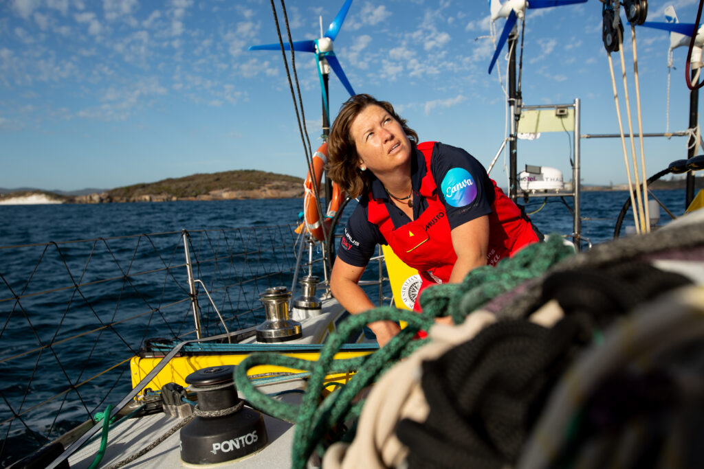 Lisa Blair pulling a rope while looking up at the sail.