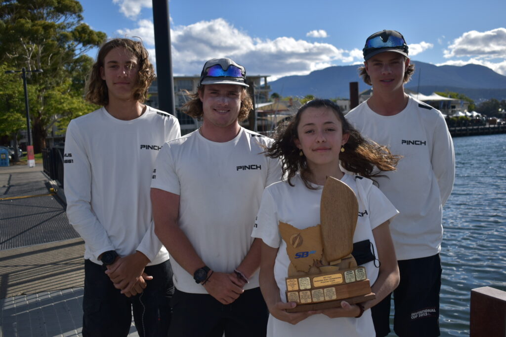 SB20 Tasmanian Champions having a group ohoto on shore, holding their trophy.