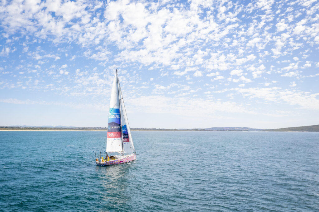 Climate Action Now sailing, llittle fluffy white clouds in the sky.