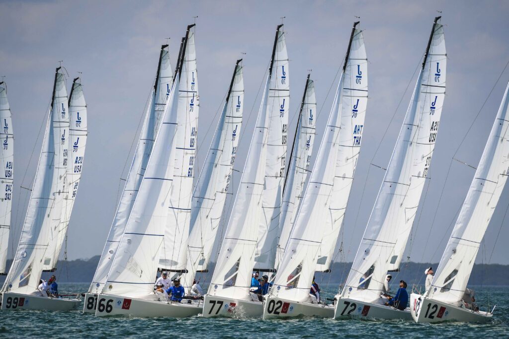 J/70 fleet sailing upwind after race start.