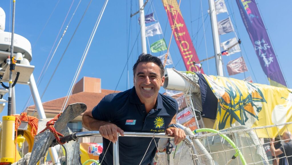 Jeronimo Santos Gonzalez, smiling, leaning over railing on board boat on dock.