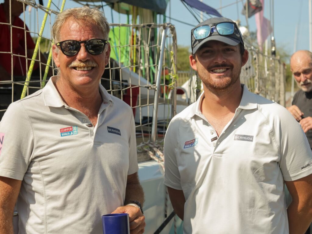  Max Rivers with Skipper David ‘Wavy’ Immelman on dock with boat behind them.