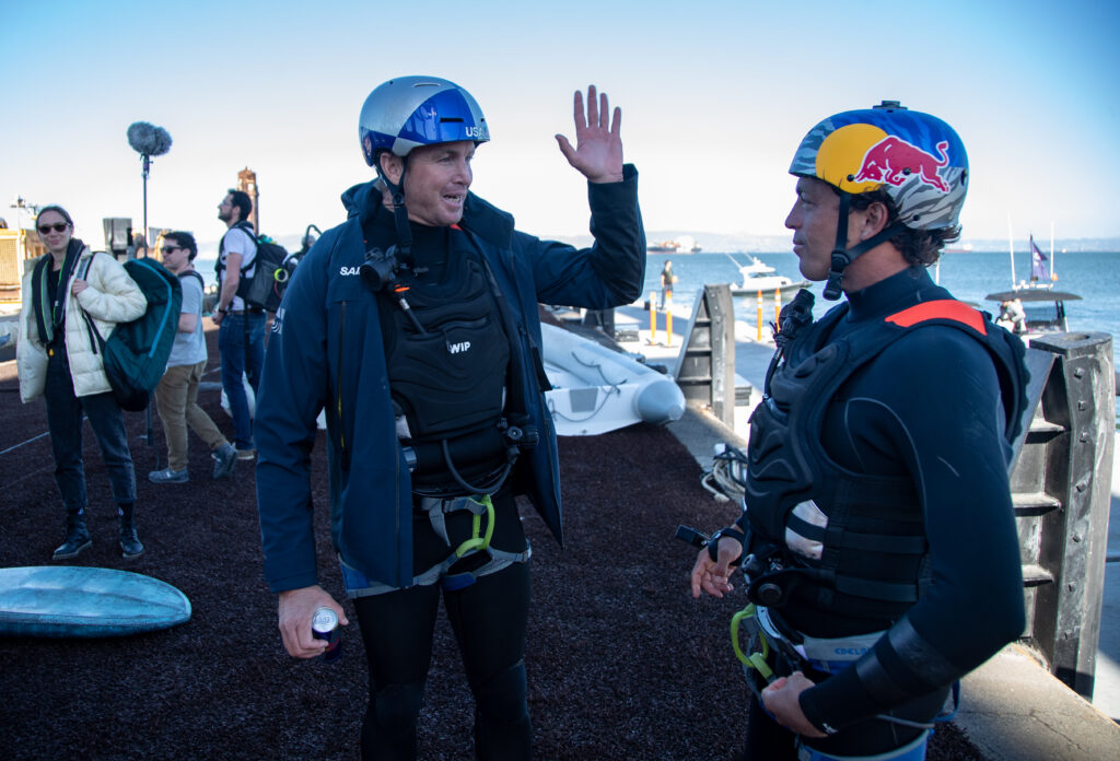 Jamie O’Brien and Kai Lenny talking onshore in wet weather gear.