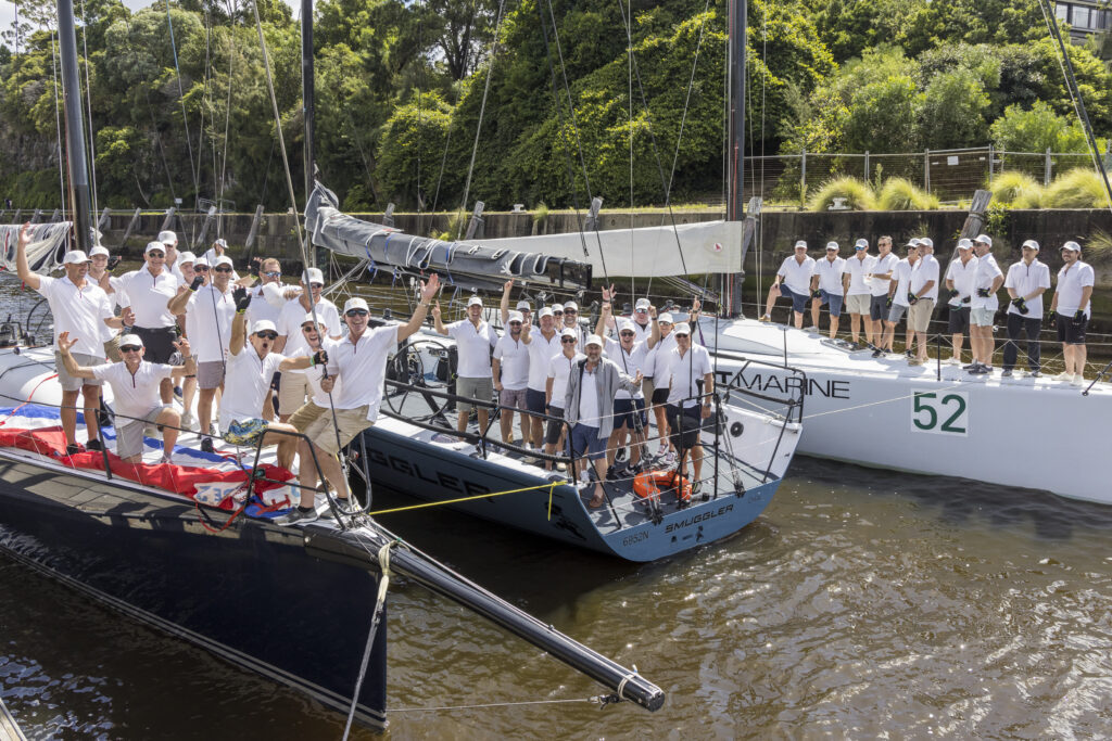 Three TP52s rafted up next to each other, crew cheering.