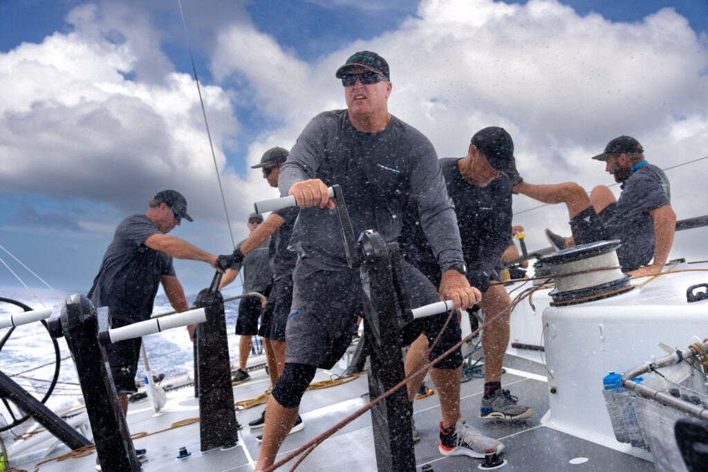 Crew grinding on winches in cockpit.