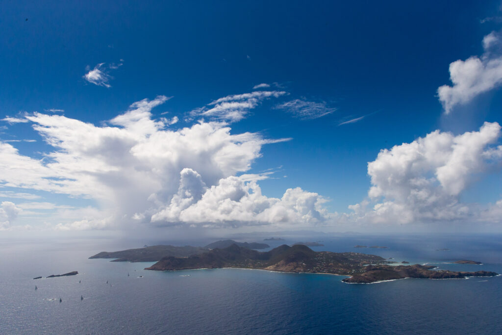 Aerial shot of island, sporadic cloud formation.