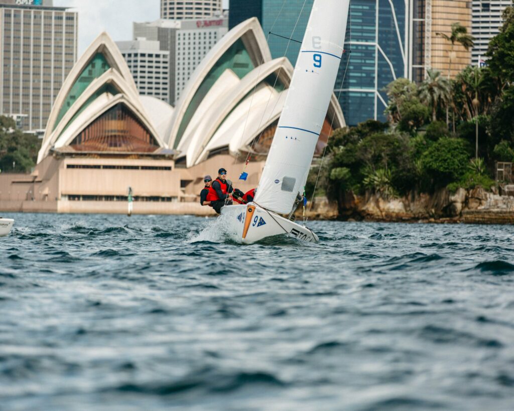 Boat sailing upwind with opera house in the background.