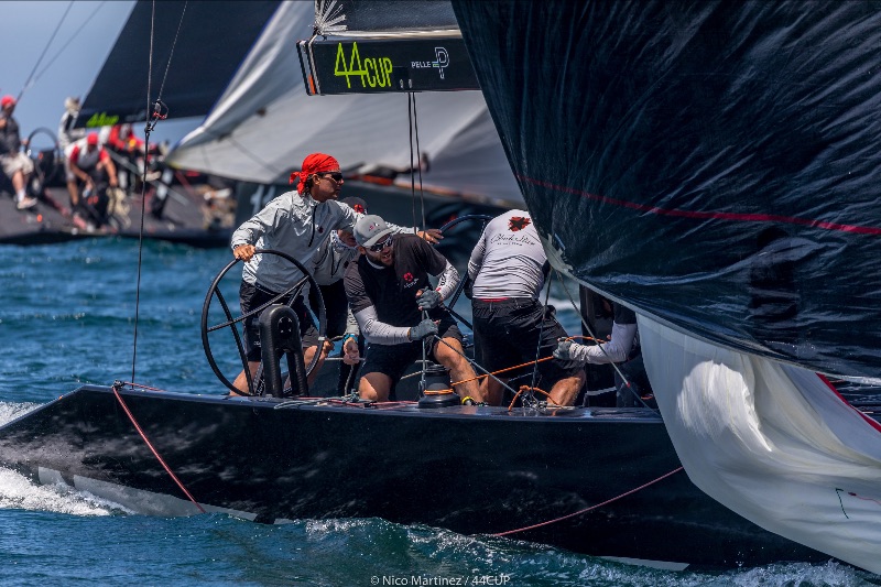 Crew trimming sail and pulling in kite (view of cockpit crew).